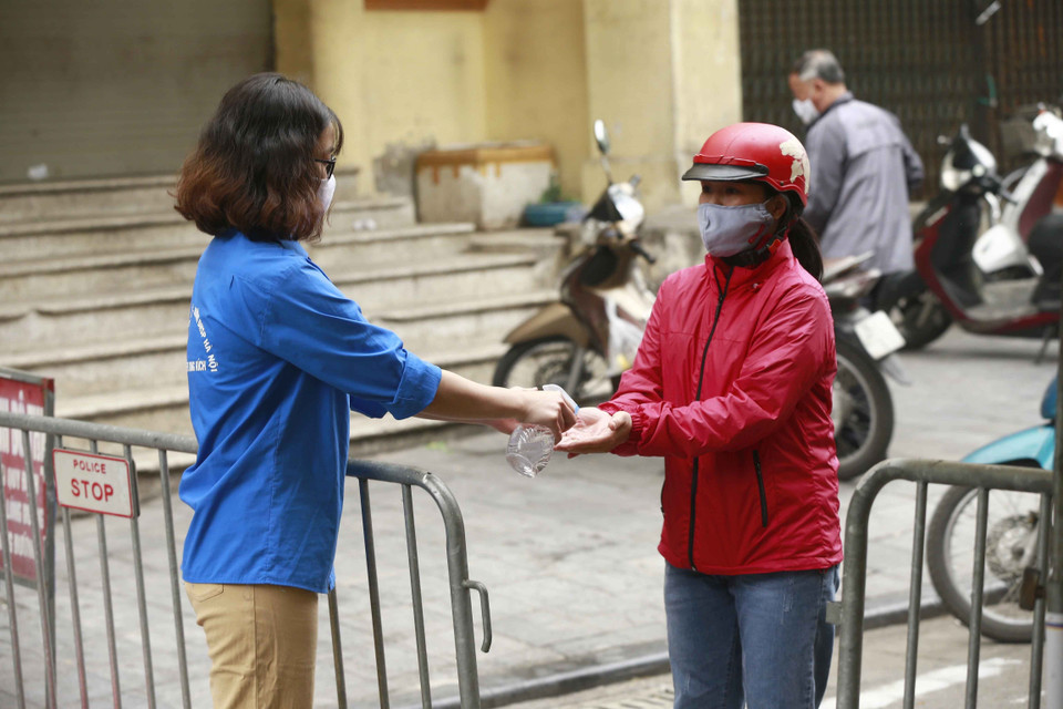 Thanh niên tình nguyện bơm dung dịch sát khuẩn cho nhân dân vào chợ Thanh Hà, phường Đồng Xuân, quận Hoàn Kiếm. (Ảnh: Doãn Tấn/TTXVN)