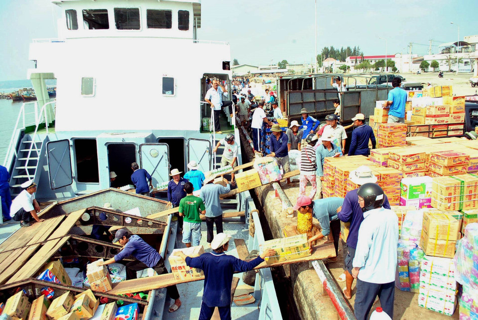 Bốc xếp hàng lên tàu tại cảng Phan Thiết để vận chuyển ra đảo Phú Quý. (Ảnh: Anh Tuấn/TTXVN)