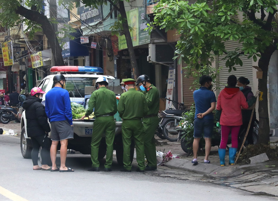 Lực lượng chức năng tuần tra, xử phạt các vi phạm giãn cách xã hội trên phố Đoàn Thị Điểm. (Ảnh: Ngọc Hà/TTXVN)