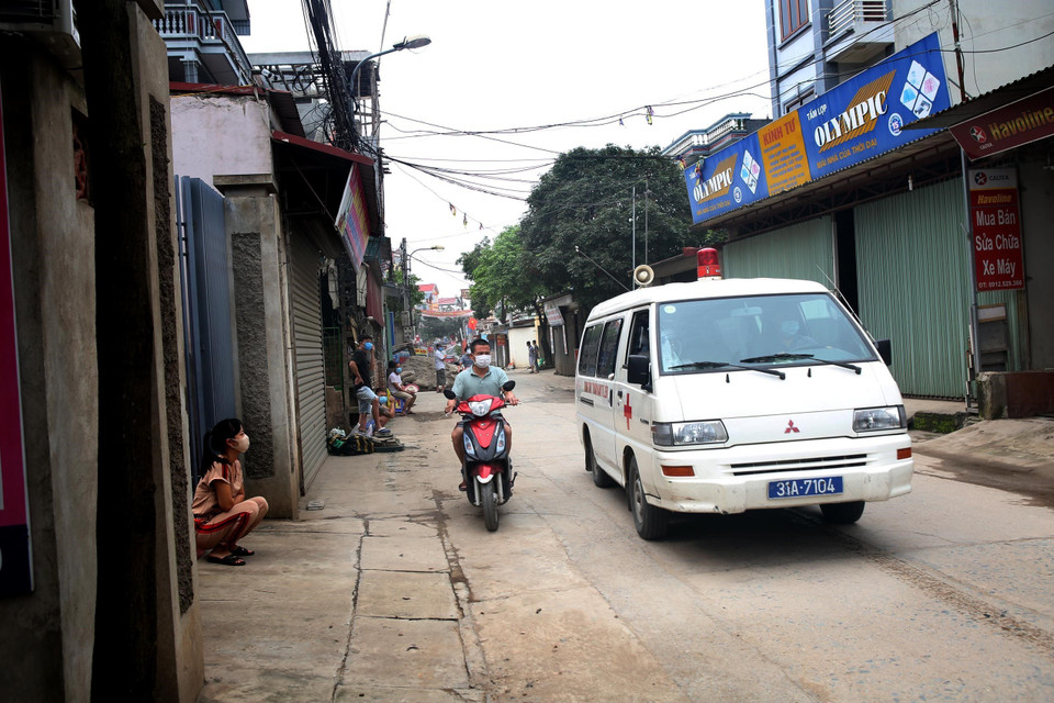 Người dân thôn Hạ Lôi dần quen với hình ảnh xe y tế, cùng các nhân viên y tế trong đồng phục bảo hộ. (Ảnh: Danh Lam/TTXVN)