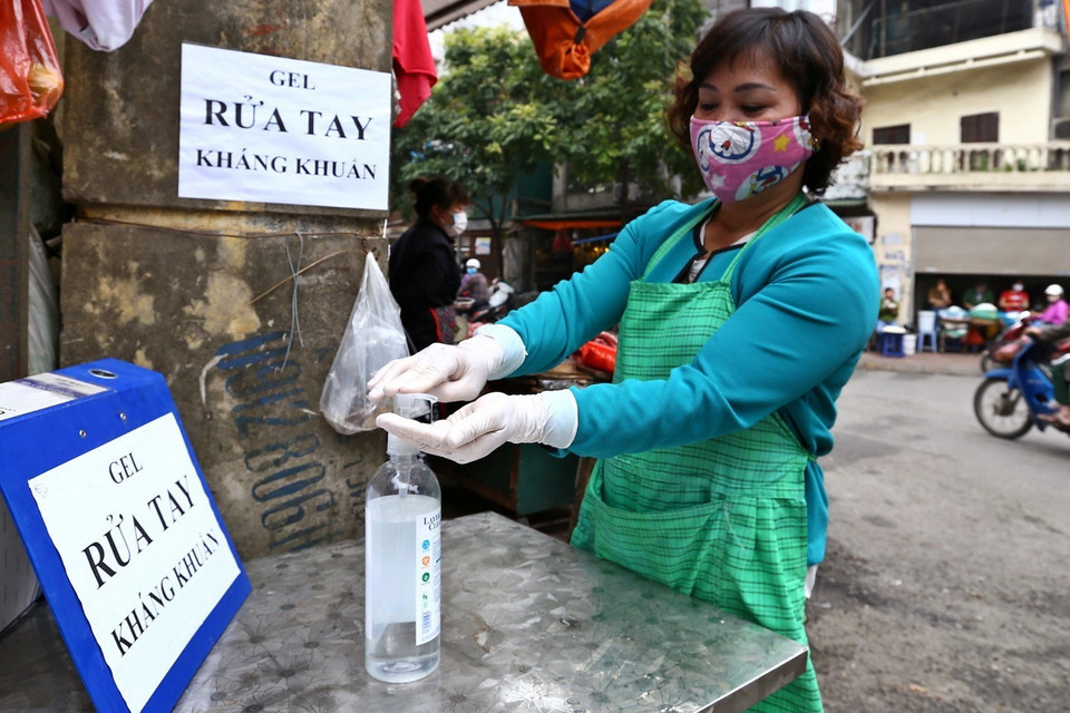 Khu vực cổng chợ có đặt bình sát khuẩn tay, nhắc nhở người dân thực hiện nghiêm các biện pháp về phòng, chống dịch bệnh. (Ảnh: Minh Quyết/TTXVN)