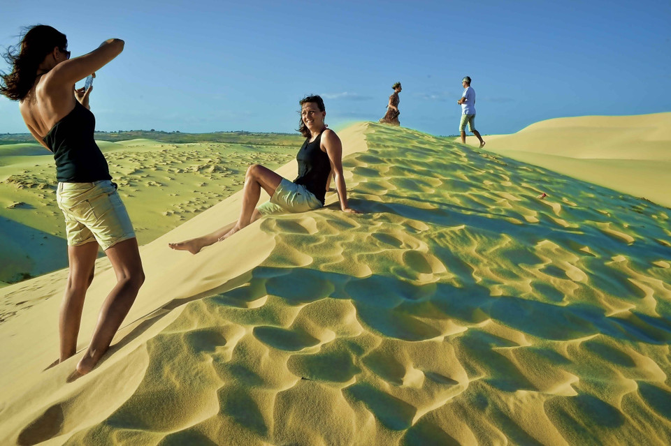 Du khách nước ngoài đắm mình với vẻ đẹp trời xanh, cát trắng, nắng vàng của Bàu Trắng, điểm du lịch hấp dẫn của tỉnh Bình Thuận thuộc địa phận thôn Bình Nhơn, xã Hòa Thắng, huyện Bắc Bình. (Ảnh: Thanh Hà/TTXVN)