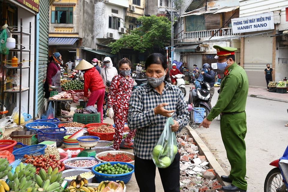 Lực lượng chức năng phường Ngọc Lâm nhắc nhở người dân thực hiện nghiêm Chỉ thị về công tác phòng, chống dịch bệnh. (Ảnh: Minh Quyết/TTXVN)