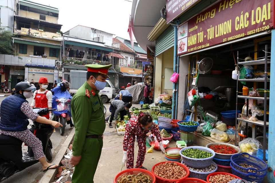 Lực lượng chức năng phường Ngọc Lâm nhắc nhở người dân thực hiện nghiêm Chỉ thị về công tác phòng, chống dịch bệnh. (Ảnh: Minh Quyết/TTXVN)