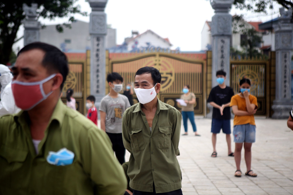 Người dân thôn Hạ Lôi xếp hàng đợi xét nghiệm. (Ảnh: Danh Lam/TTXVN)