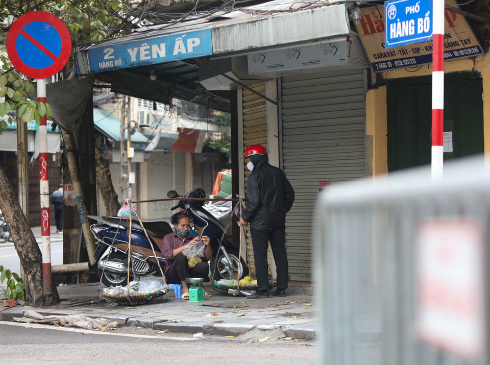 Chiều 12/4, những người bán hàng rong vẫn đi tới nhiều ngõ, phố của Hà Nội để bán hàng tiềm ẩn nguy cơ lây lan dịch bệnh. (Ảnh: Thanh Tùng/TTXVN)
