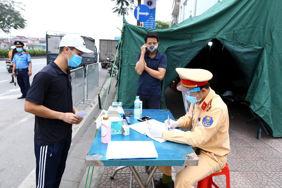 Chủ phương tiện kê khai thông tin tại chốt kiểm soát phía Bắc cầu Chương Dương hướng vào nội thành. (Ảnh: Minh Quyết/TTXVN)