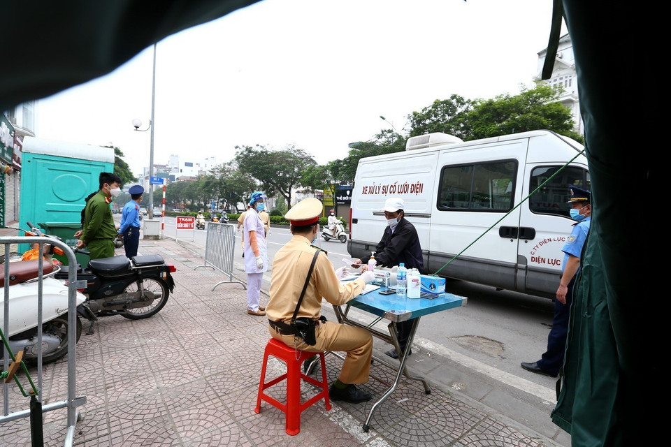Chủ phương tiện kê khai thông tin dịch tễ tại chốt kiểm soát phía Bắc cầu Chương Dương hướng vào nội thành. (Ảnh: Minh Quyết/TTXVN)
