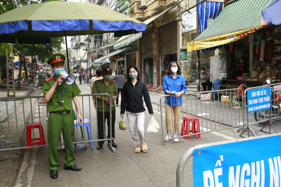 Các lực lượng chức năng làm nhiệm vụ giãn cách xã hội tại phố Nguyễn Thiện Thuật, phường Đồng Xuân, quận Hoàn Kiếm. (Ảnh: Doãn Tấn/TTXVN)