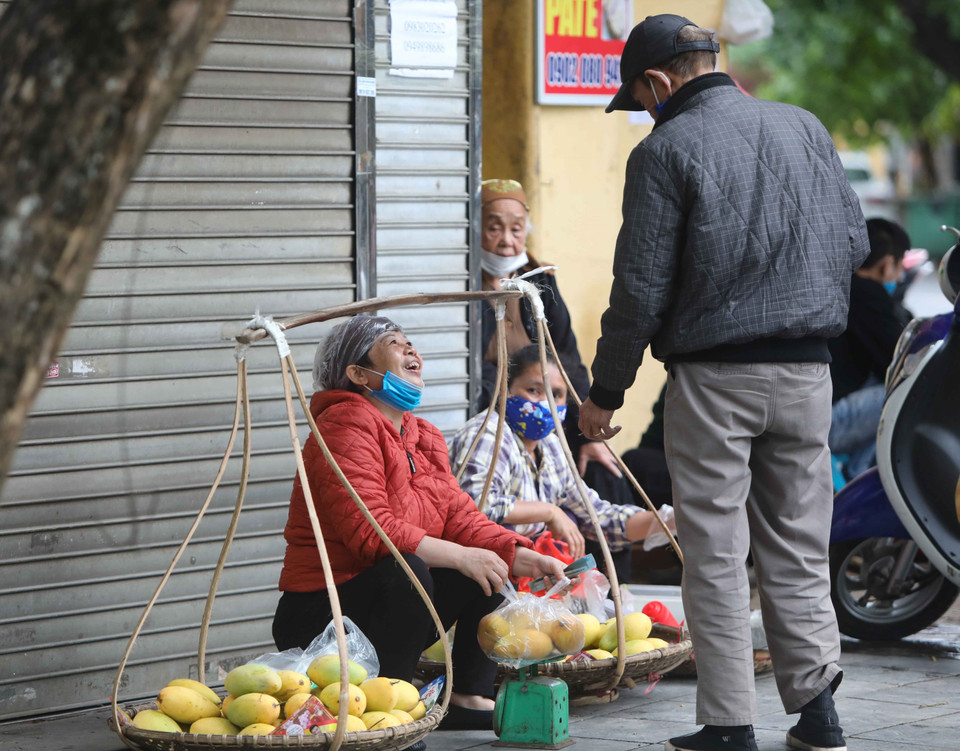 Trong lúc bán hàng, người mua hay người bán vô tình bỏ khẩu trang rất dễ lây lan dịch bệnh. (Ảnh: Thanh Tùng/TTXVN)