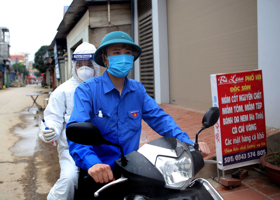 Nhân dân thôn Hạ Lôi hỗ trợ, giúp đỡ các nhân viên y tế, một hình ảnh thường thấy tại đây. (Ảnh: Danh Lam/TTXVN)