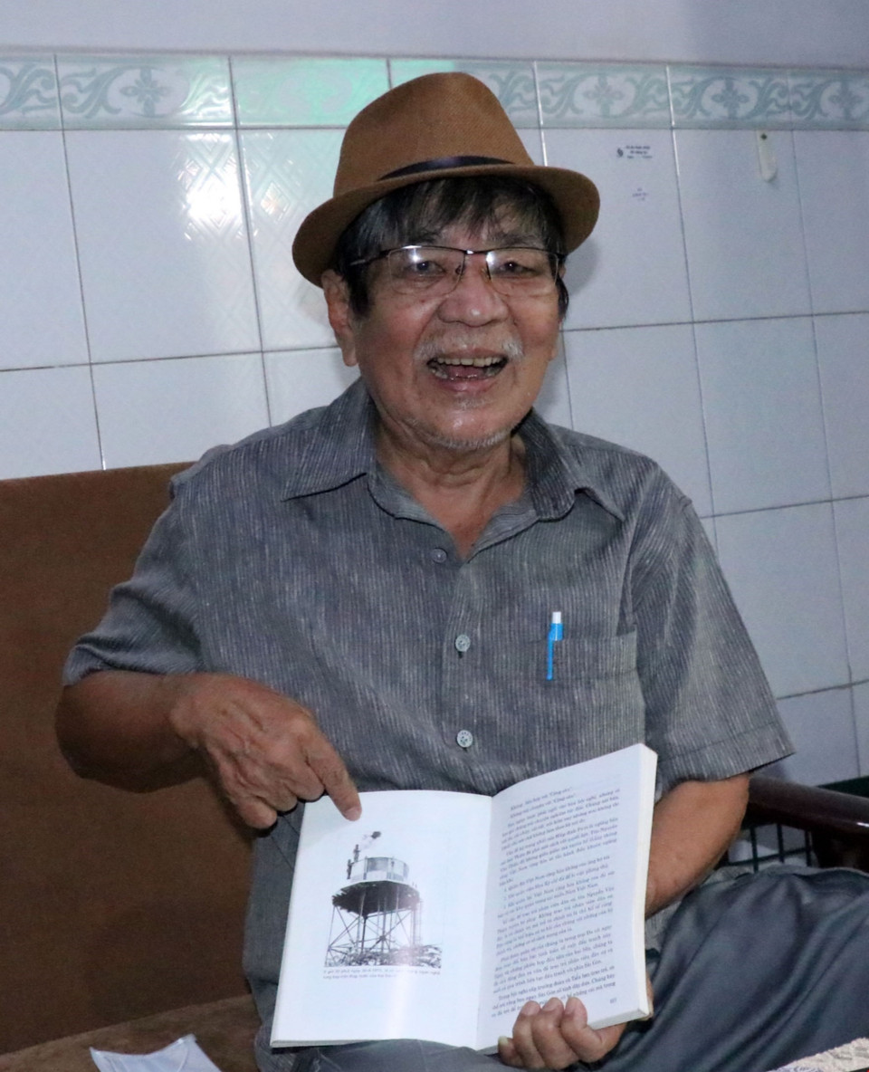 Cựu chiến binh Phùng Bất Diệt bên tấm ảnh ghi lại thời khắc lịch sử ông đã chụp sáng 30/4/1975 tại trại Davis. (Ảnh: Xuân Khu/TTXVN)