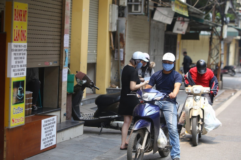 Một số hàng quán bắt đầu mở bán, nên đã có khách tập trung đến mua hàng. (Ảnh: Minh Quyết/TTXVN)