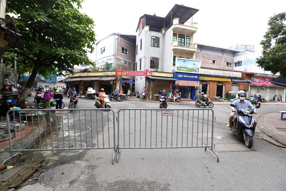 Lập hàng rào trước cổng vào chợ Gia Lâm (Long Biên). (Ảnh: Minh Quyết/TTXVN)