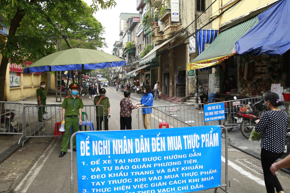 Các lực lượng chức năng làm nhiệm vụ giãn cách xã hội tại phố Nguyễn Thiện Thuật, phường Đồng Xuân, quận Hoàn Kiếm. (Ảnh: Doãn Tấn/TTXVN)