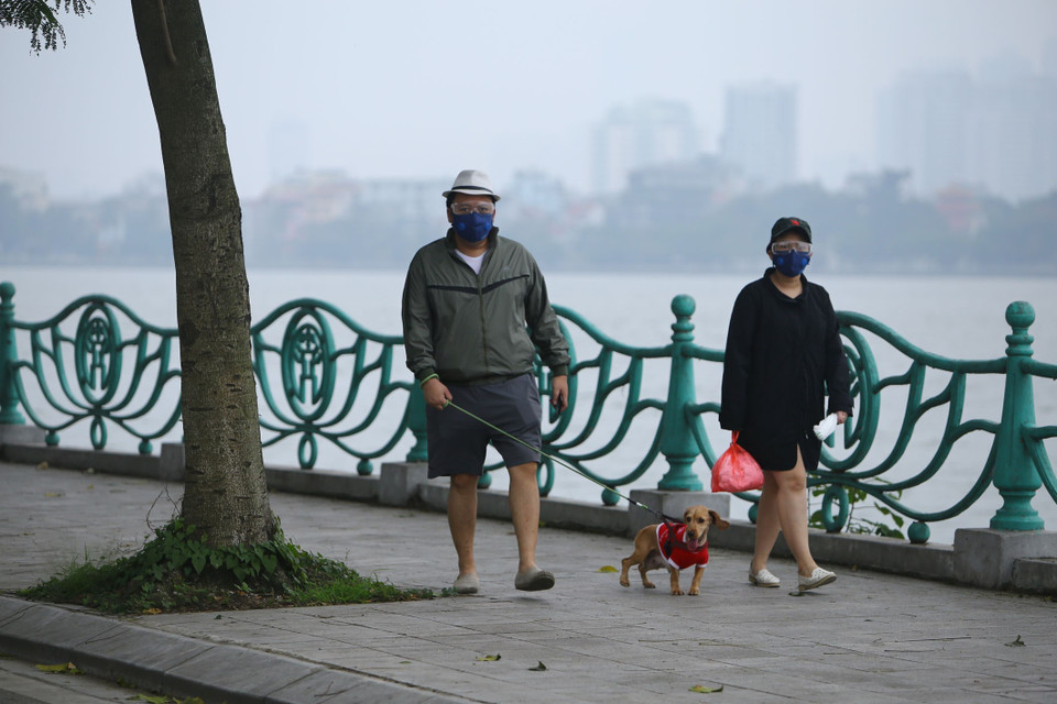 Một số gia đình thản nhiên dắt chó đi bộ lững thững trên tuyến đường quanh Hồ Tây như không hề có dịch hay không có cảnh báo. (Ảnh: Anh Tuấn/TTXVN)