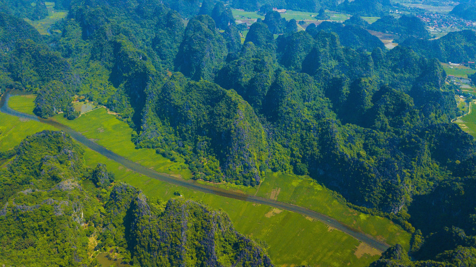Nhìn từ trên cao xuống những thửa ruộng kéo dài từ trong mép chân núi đá vôi ra gần giữa dòng sông. (Ảnh: Minh Đức/TTXVN)