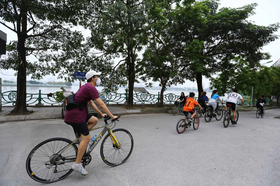 Nhiều tốp tập thể dục theo hình thức đạp xe trên tuyến đường quanh Hồ Tây. (Ảnh: Anh Tuấn/TTXVN)