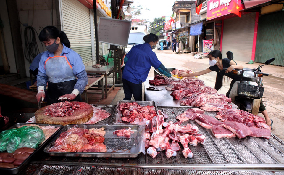 Người dân mua bán tại một cửa hàng thịt lợn tại thôn Hạ Lôi. (Ảnh: Danh Lam/TTXVN)