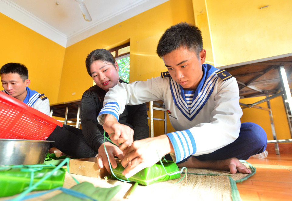 Các chiến sỹ gói bánh chưng gói bằng lá bàng vuông. (Ảnh: Văn Dũng/TTXVN)