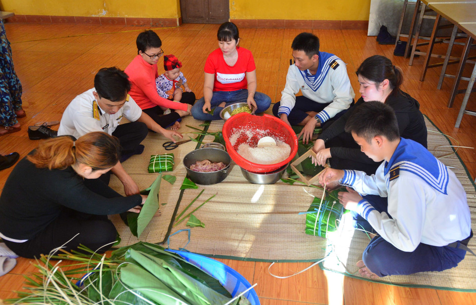 Các cán bộ, chiến sỹ và người dân trên đảo Sinh Tồn gói bánh chưng. (Ảnh: Văn Dũng/TTXVN)