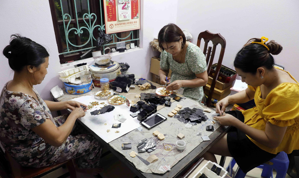 Các công đoạn cắt dòng và sang vàng tại gia đình nghệ nhân Nguyễn Anh Chung. (Ảnh: Trần Việt/TTXVN)