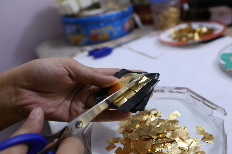 Vàng sau khi cán mỏng được cắt thành miếng nhỏ để đập quỳ. (Ảnh: Hoàng Hiếu/TTXVN)