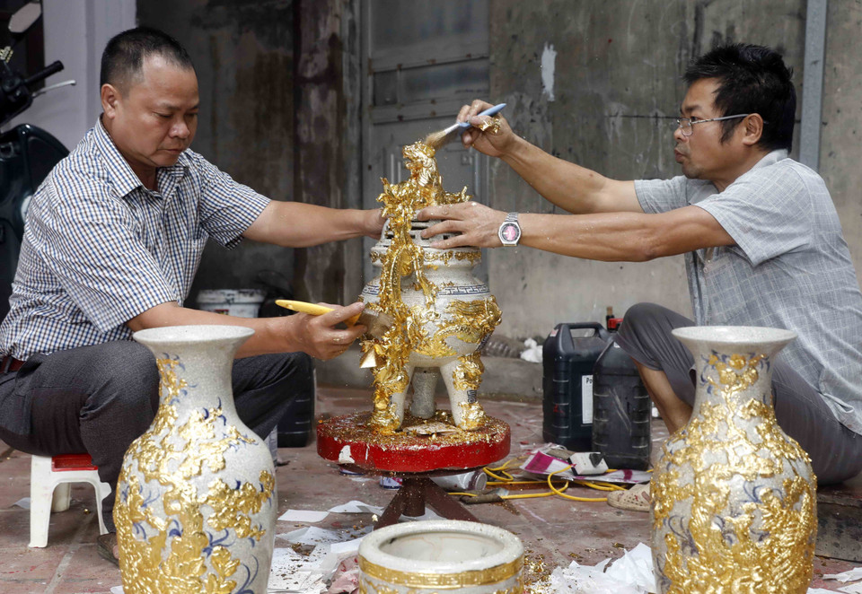 Các sản phẩm dát vàng trên sứ tại gia đình nghệ nhân Nguyễn Anh Chung. (Ảnh: Trần Việt/TTXVN)