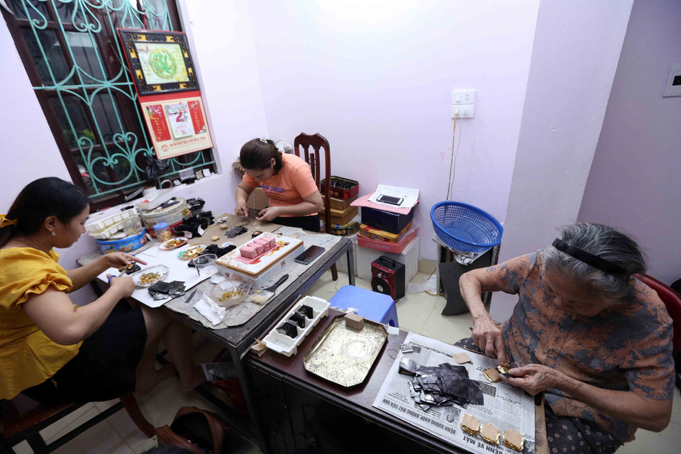Các công đoạn cắt dòng và sang vàng tại gia đình nghệ nhân Nguyễn Anh Chung. (Ảnh: Hoàng Hiếu/TTXVN)