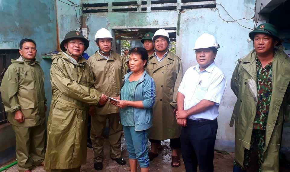 Bí thư Tỉnh ủy, Chủ tịch Ủy ban Nhân dân tỉnh Bình Định Hồ Quốc Dũng trao tiền hỗ trợ cho gia đình bà Trần Thị Báu, thị xã An Nhơn. (Ảnh: Tường Quân/TTXVN)