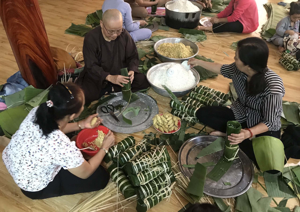 Người dân huyện Đạ Tẻh (Lâm Đồng) gói bánh tét để hỗ trợ cho các tỉnh miền Trung. (Ảnh: Nguyễn Dũng/TTXVN)