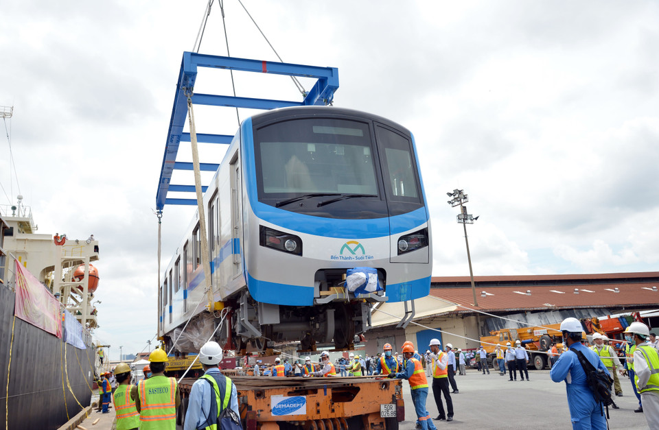 Các chuyên gia, kỹ sư đưa toa xe đầu tiên của đoàn tàu xuống xe siêu trường, siêu trọng. (Ảnh: Tiến Lực/TTXVN)