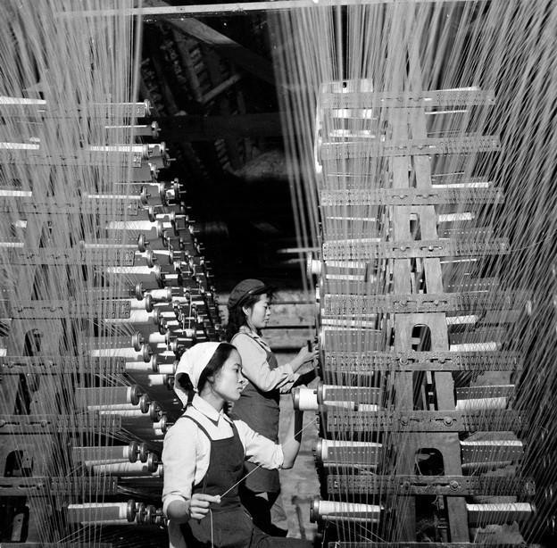 Trong các nhà máy, xí nghiệp, công trường có phong trào “nhận thêm việc, làm thêm giờ, thay cho người đi chiến đấu”, phong trào “phụ nữ tự quản” phát triển rất sôi nổi. Trong ảnh: Công nhân cơ điện hoàn chỉnh máy dệt vải (1974). (Ảnh: Trần Vũ Hanh/TTXVN)