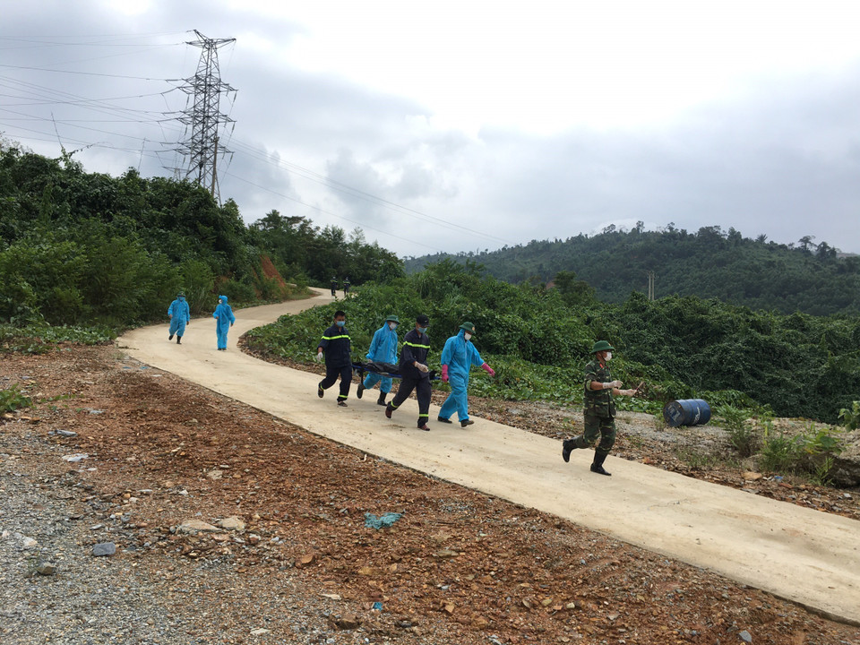Lực lượng chức năng chuyển nạn nhân ra khỏi khu vực tìm kiếm. (Ảnh: Đỗ Trưởng/TTXVN)