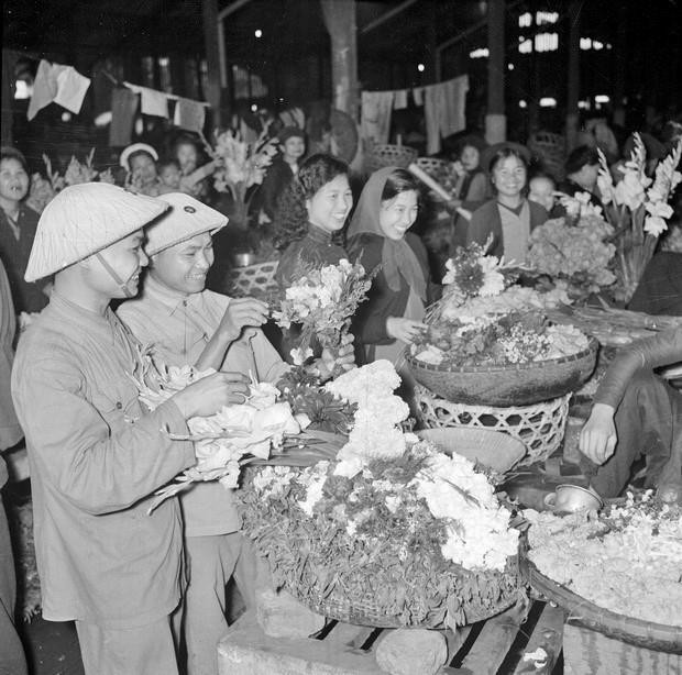 Bộ đội và phụ nữ Thủ đô vui tươi đi mua sắm hoa Tết Bính Thân, năm 1956. (Nguồn: TTXVN)