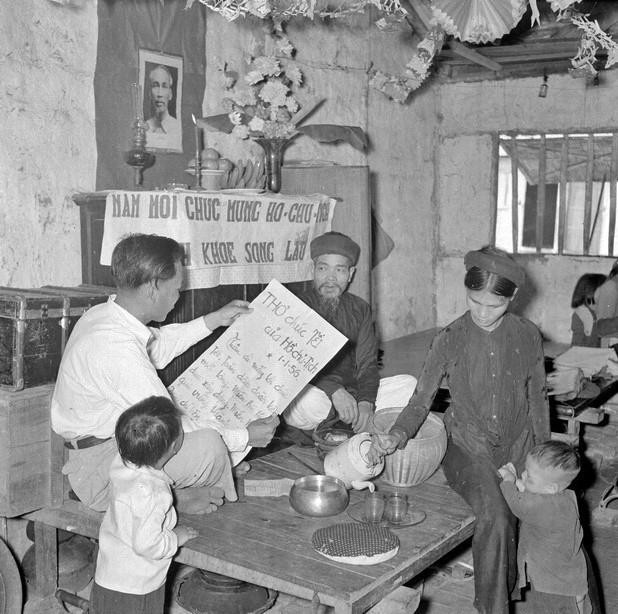 Sáng mồng 1 Tết Bính Thân 1956, cả gia đình ngồi trước bàn thờ Tổ quốc nghe đọc thư chúc Tết của Bác Hồ. (Ảnh: TTXVN)