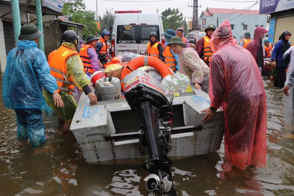 Ca nô của lực lượng chức năng được huy động đưa hàng cứu trợ tới người dân đang bị cô lập do lũ. (Ảnh: Võ Mạnh Thành/TTXVN)