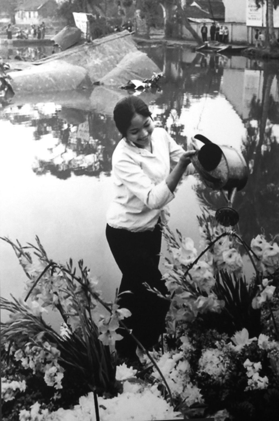 Hình ảnh cô gái tưới hoa bên xác chiếc máy bay Mỹ B-52 rơi ở hồ Hữu Tiệp, làng Ngọc Hà (Hà Nội) tô điểm thêm cho chiến thắng của quân và dân Hà Nội trong chiến thắng lịch sử "Hà Nội - Điện Biên Phủ trên không" tháng 12/1972. (Ảnh: Văn Bảo/TTXVN)