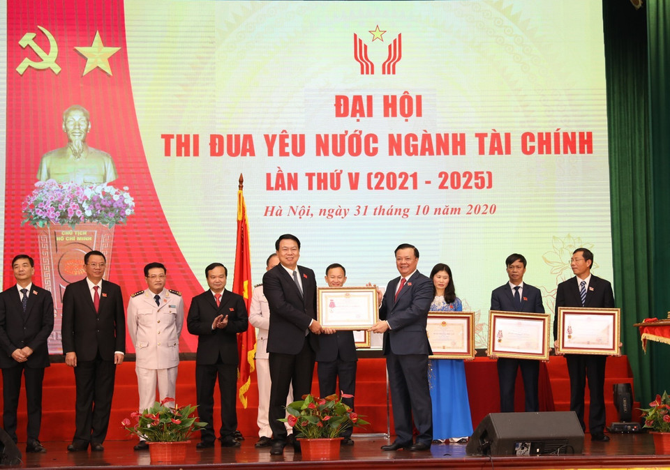 Bộ trưởng Bộ Tài chính Đinh Tiến Dũng trao Huân chương Độc lập các hạng của Chủ tịch nước tặng cá nhân, tập thể. (Ảnh: Phạm Hậu/TTXVN)