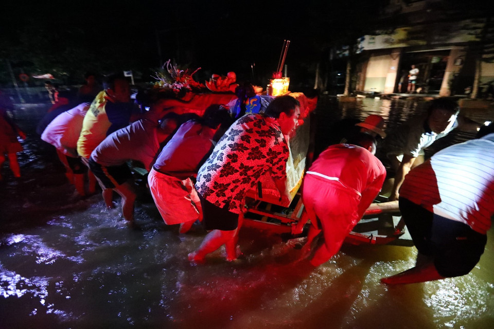 Tranh thủ nước rút, ngay trong đêm gia đình có người mất di chuyển ngay linh cữu đi an táng. (Ảnh: Thành Đạt/TTXVN)
