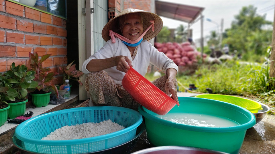 Bà Lư Thị Nguyệt, 72 tuổi, thị trấn Chợ Lách tham gia gói bánh tét ủng hộ đồng bào miền Trung. (Ảnh: Trần Thị Thu Hiền/TTXVN)