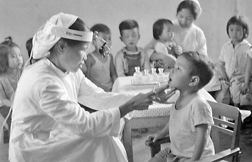 Xí nghiệp may 10 Hà Nội coi trọng công tác bảo vệ sức khỏe cho con cán bộ, công nhân, thường xuyên khám sức khỏe định kỳ cho trẻ (1970). (Ảnh: Trần Phác/TTXVN)