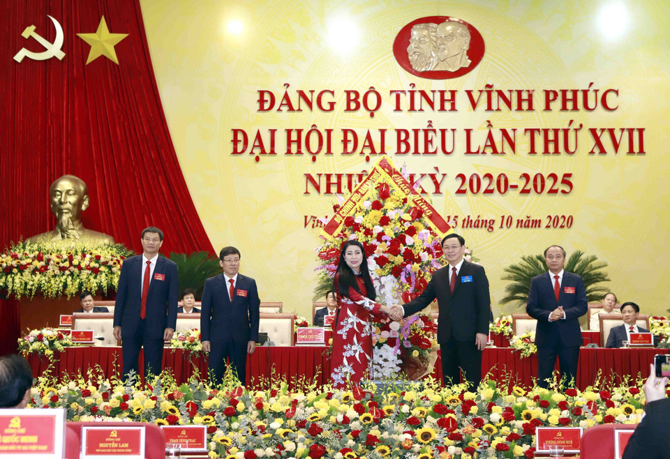 Ông Vương Đình Huệ, Ủy viên Bộ Chính trị, Bí thư Thành ủy Hà Nội tặng hoa chúc mừng lãnh đạo tỉnh Vĩnh Phúc. (Ảnh: Hoàng Hùng/TTXVN)