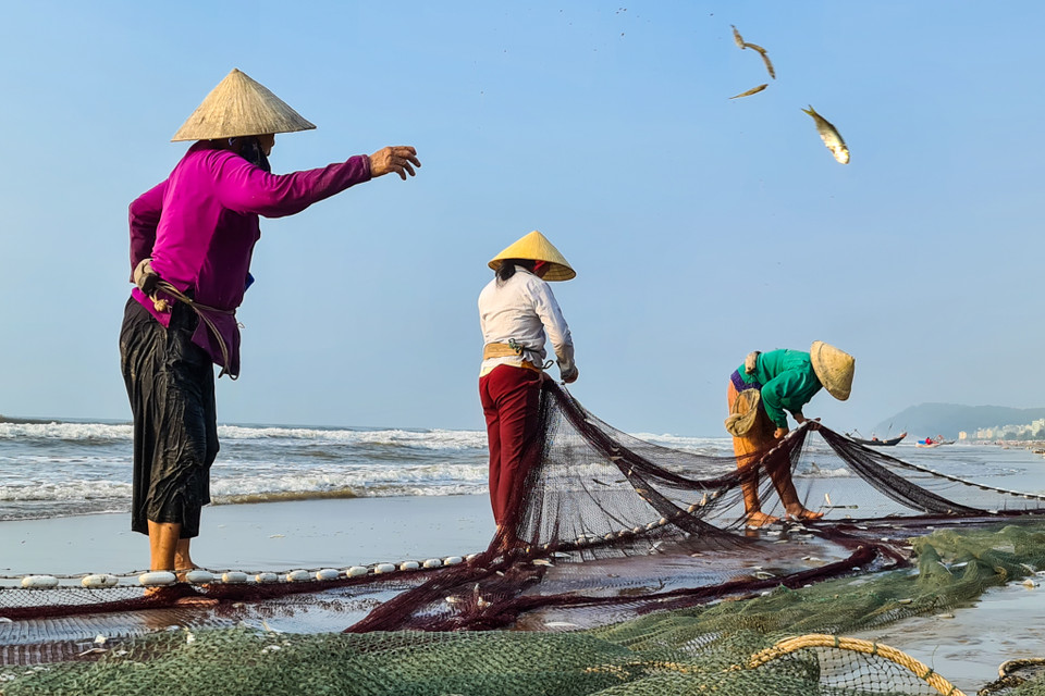Người dân làng chài gỡ lưới. (Nguồn: Vietnam+)