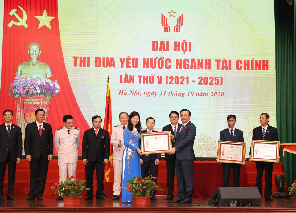 Bộ trưởng Bộ Tài chính Đinh Tiến Dũng trao Huân chương Độc lập các hạng của Chủ tịch nước tặng cá nhân, tập thể. (Ảnh: Phạm Hậu/TTXVN)