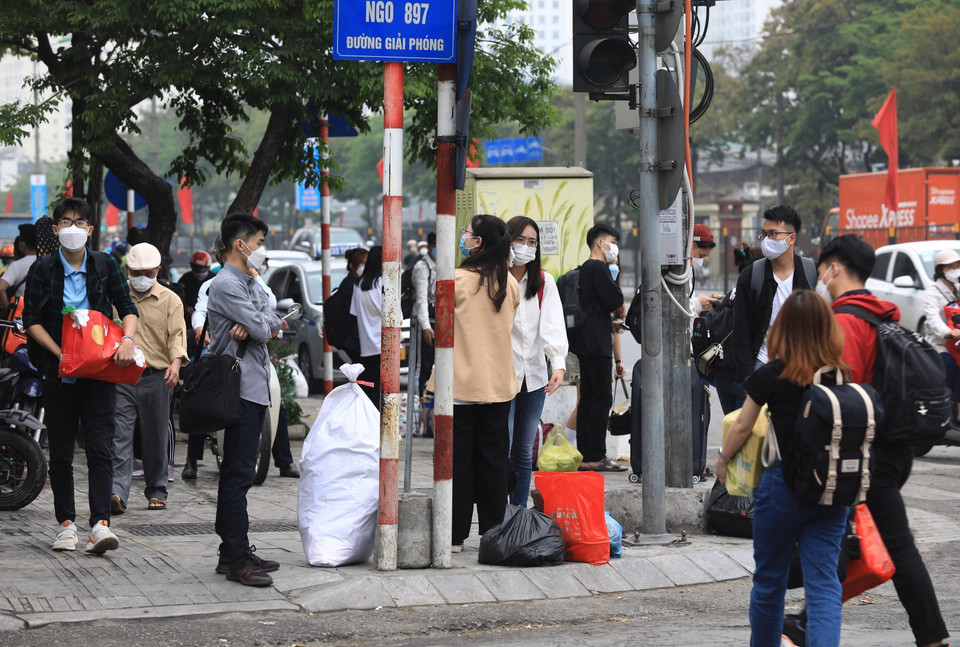 Người dân đổ ra đường Giải Phóng chờ đón xe buýt sau khi từ các địa phương về đến Bến xe Giáp Bát, chiều 11/4. (Ảnh: Hoàng Hiếu/TTXVN)