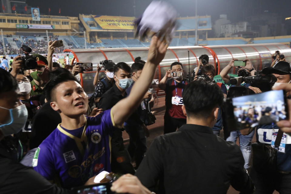 Quang Hải tặng áo đấu cho người hâm mộ sau trận đấu. (Ảnh: Minh Quyết/TTXVN)