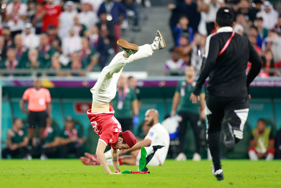 Cổ động viên này đã có màn nhào lộn trên sân cỏ trước khi bị an ninh can thiệp đưa ra ngoài. (Ảnh: Hải An/Vietnam+)