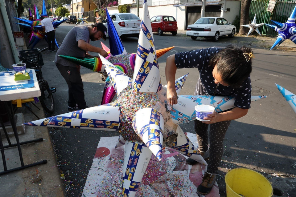 Trước khi phủ vật liệu trang trí, người thợ quét lên bề mặt một lớp keo dính. (Ảnh: Phi Hùng/TTXVN)