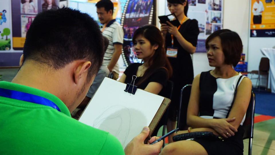 Ở gian hàng này, mất vài phút, khách tham quan có ngay một chân dung hoạt hình giống hệt mình. (Ảnh: Võ Phương/Vietnam+)